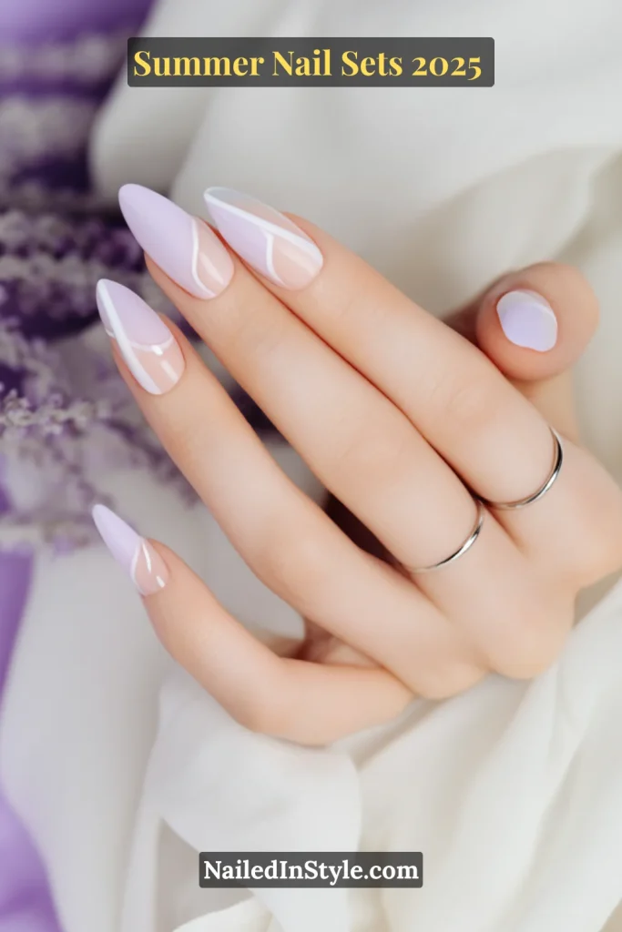 Long almond-shaped nails in lilac and milky white with delicate curved French tips, styled on fair skin tone.