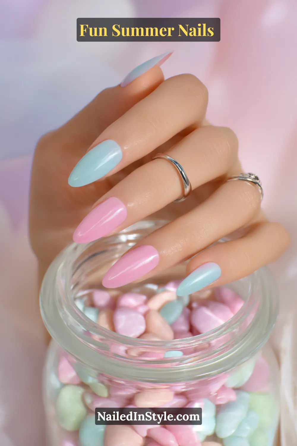 Hand with fair skin tone wearing pastel pink and aqua summer nails, soft and vibrant shades creating a delicate contrast.