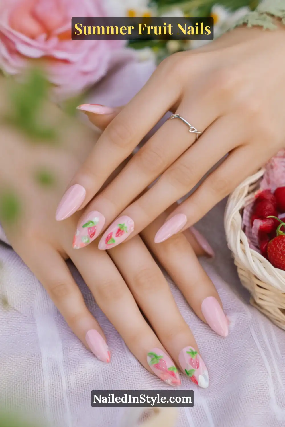 Delicate pink nails with hand-painted strawberry designs and green leaves on a fair skin tone.
