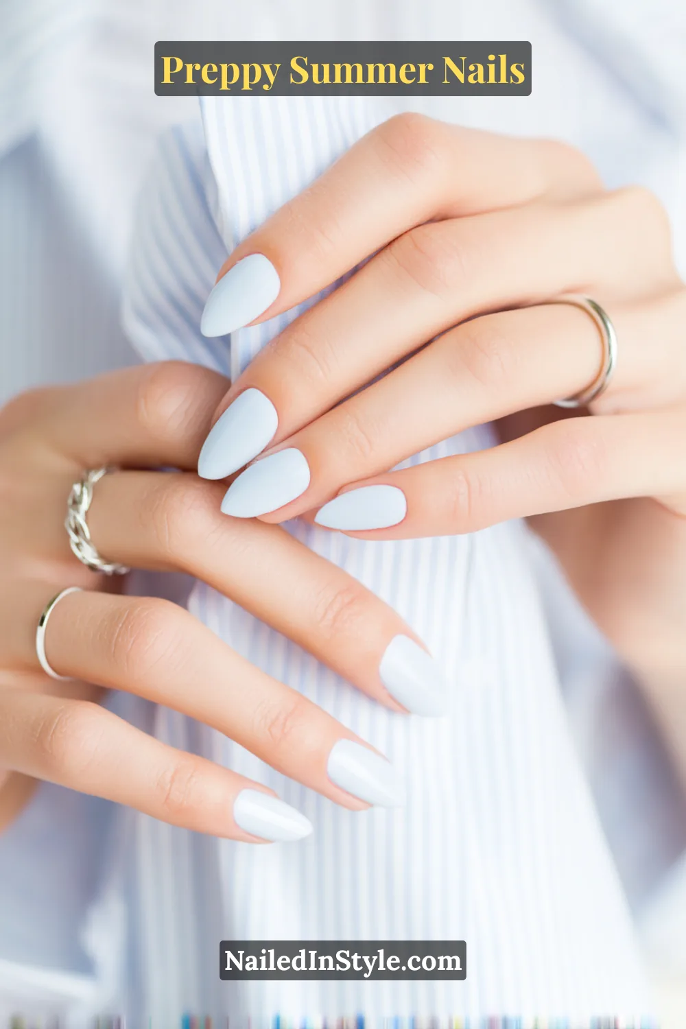 Hands with glossy baby blue summer nails on fair skin tone, styled with silver rings.