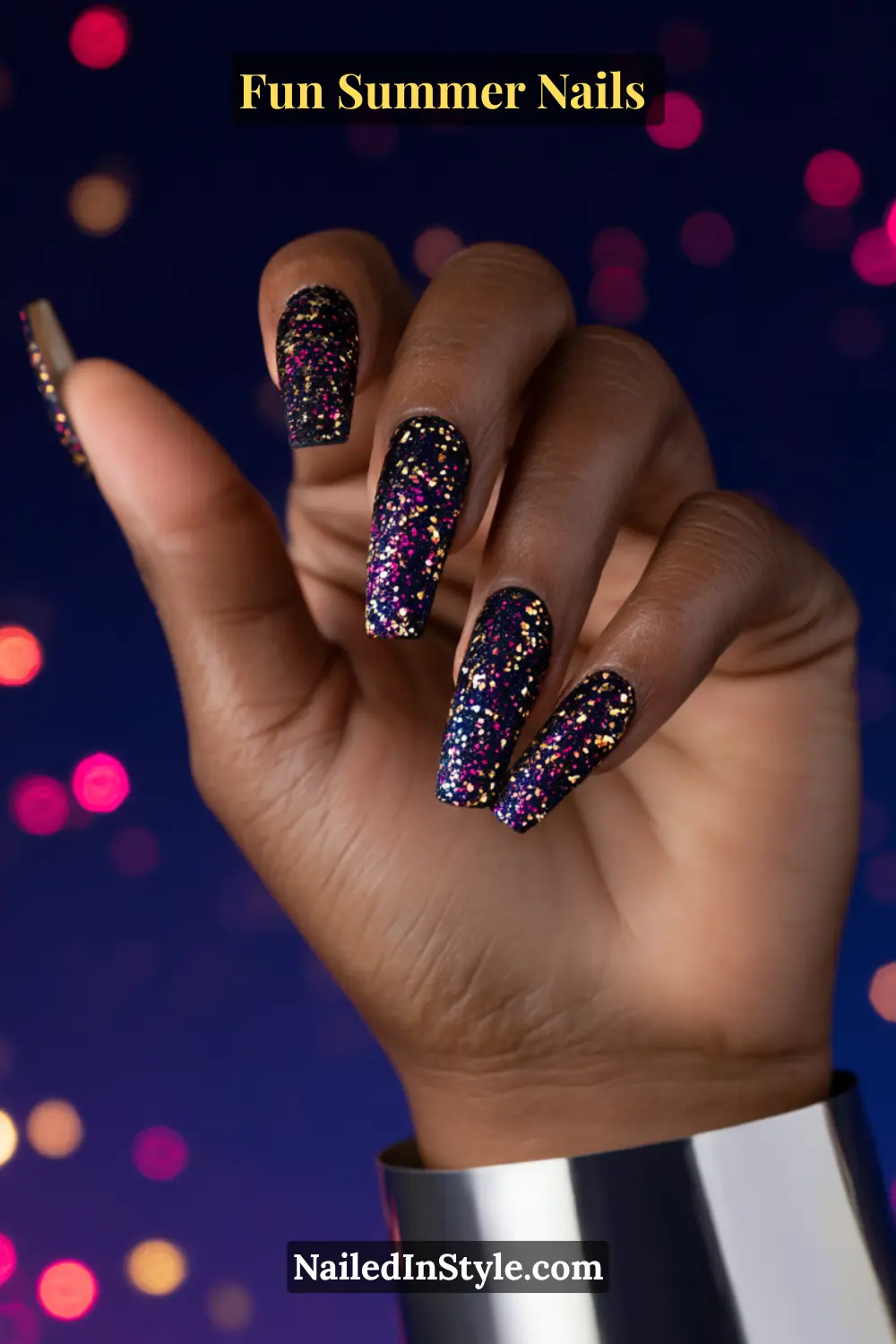 Hand with long square black nails covered in multicolor glitter, resembling fireworks in the night sky.