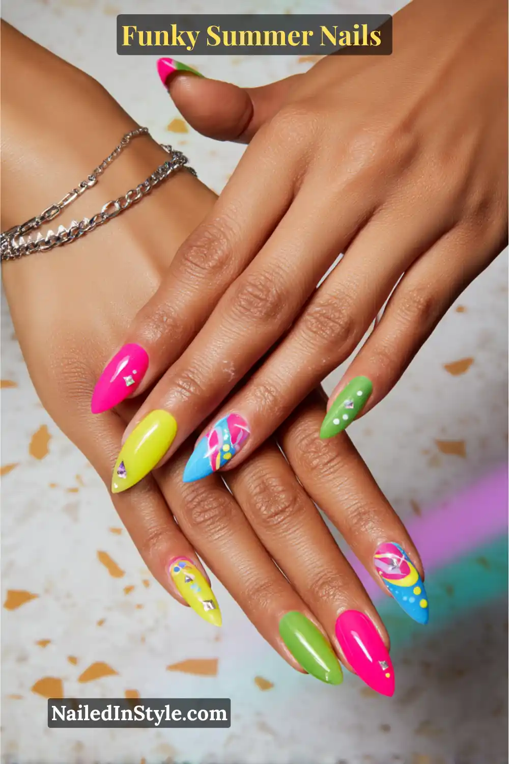 Funky Summer Nails Bright and bold stiletto nails with a mix of neon pink, lime green, and electric yellow polish, paired with accent nails featuring geometric patterns, dots, and rhinestone embellishments for a fun, playful summer vibe.