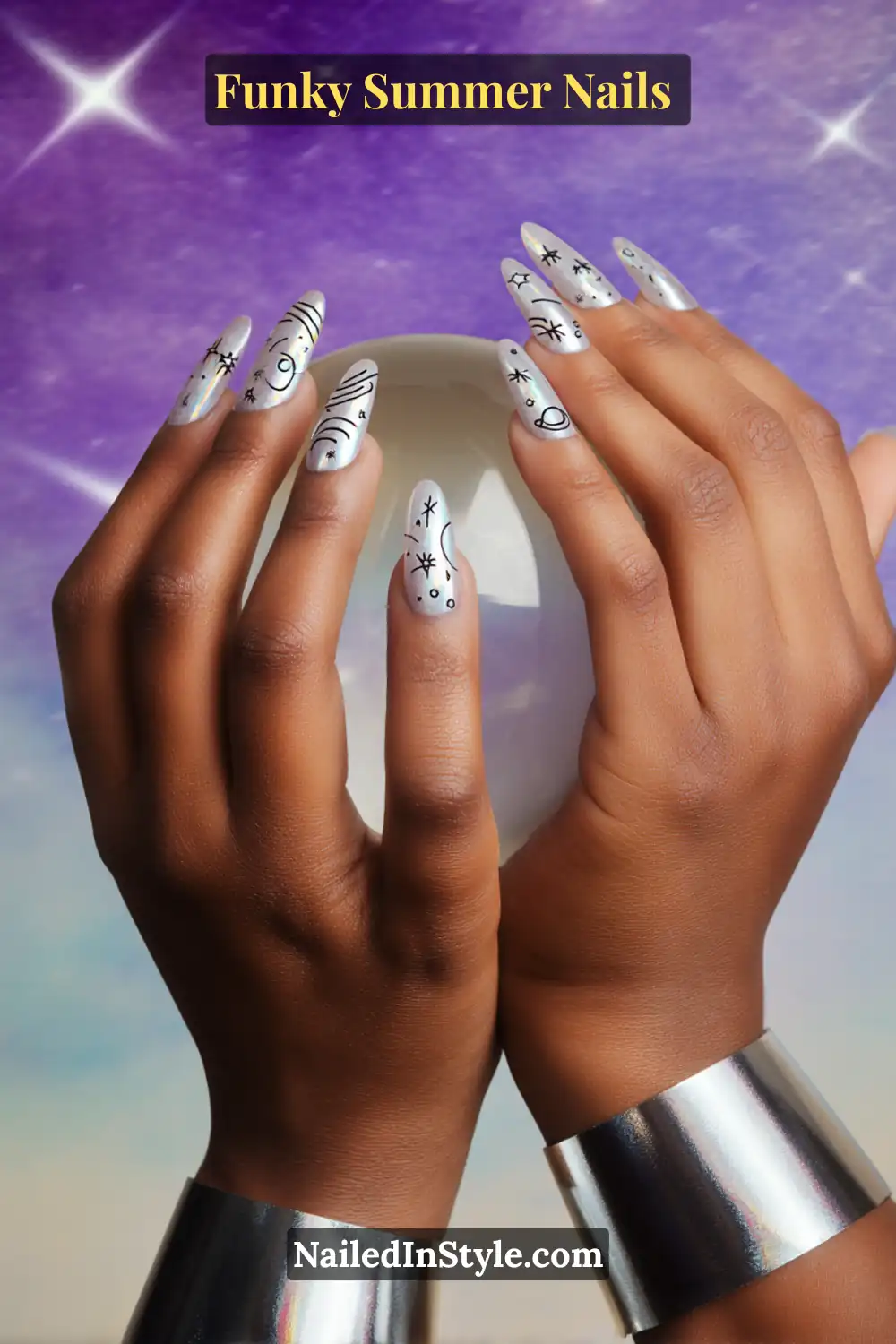 Hands with long silver chrome nails featuring black doodles of stars, moons, and cosmic shapes, giving a futuristic galaxy-inspired funky summer nail design.