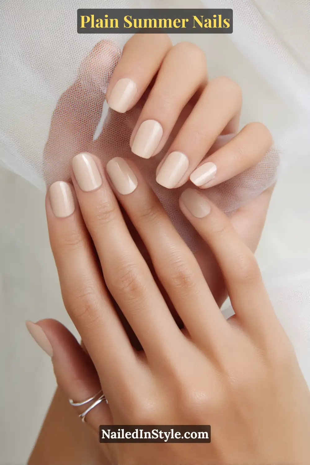 Plain Summer Nails 2025: Simple & Timeless Beauty 12 Close-up of hands with short, neatly shaped nails painted in glossy beige nude polish, showcasing a sleek and polished summer nail look.