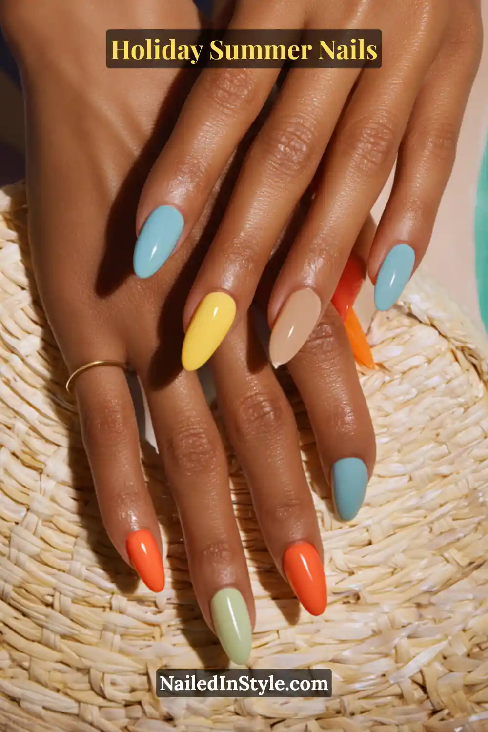 Holiday Summer Nails Close-up of hands with multi-colored nails in pastel blue, yellow, nude, mint, and orange shades, styled with a summer straw accessory.