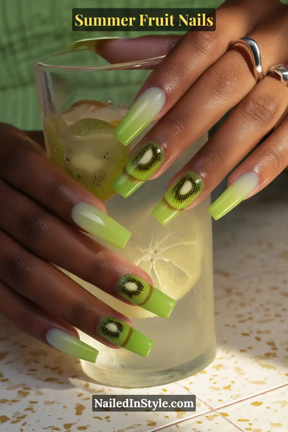 Long square-shaped nails with a smooth green ombre, accented by realistic kiwi slice art on select nails.