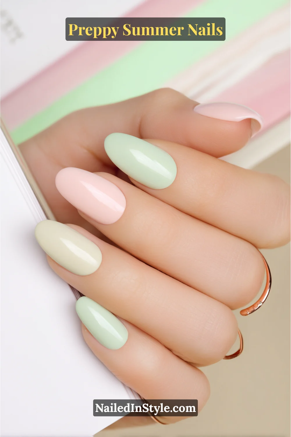 Hand with glossy pastel summer nails in mint green, blush pink, and ivory on light skin tone.