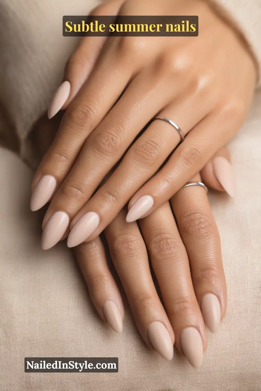 Elegant almond-shaped nails painted in matte nude polish, creating a refined and minimalist summer look.