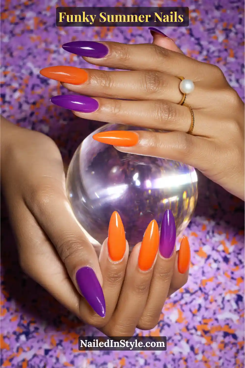 Close-up of almond-shaped nails on medium-toned skin, painted in alternating glossy purple and orange shades. The bold color combo pops beautifully against golden undertones, creating a striking summer look.