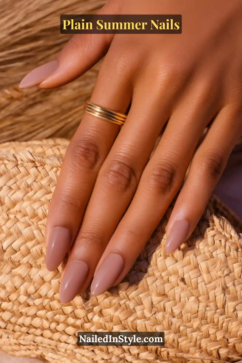 Plain Summer Nails 2025: Simple & Timeless Beauty 9 Close-up of medium skin tone hand with almond-shaped nails in rosy nude and taupe polish, designed to enhance golden undertones.