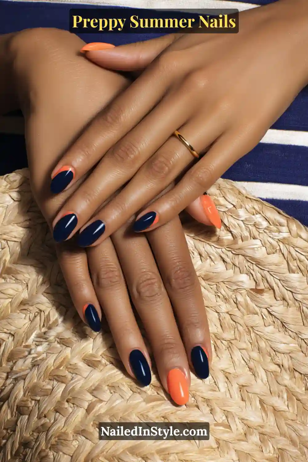 Hands with glossy navy and coral summer nails on medium golden skin tone.