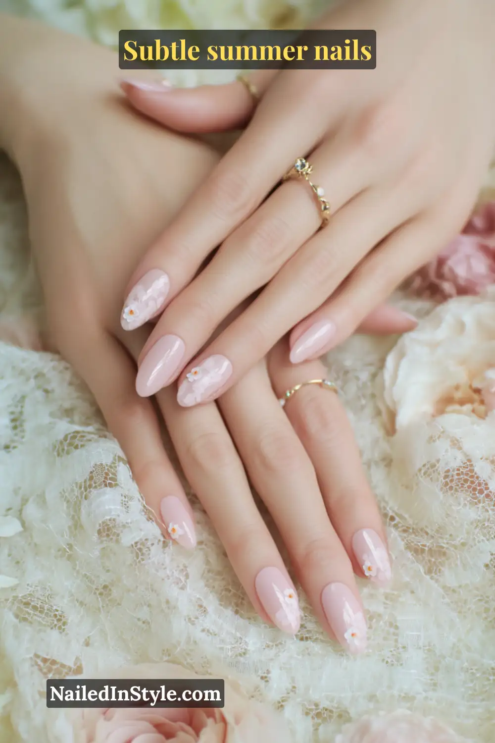 Soft blush pink almond nails with a delicate micro white flower accent placed near the cuticle on each nail.