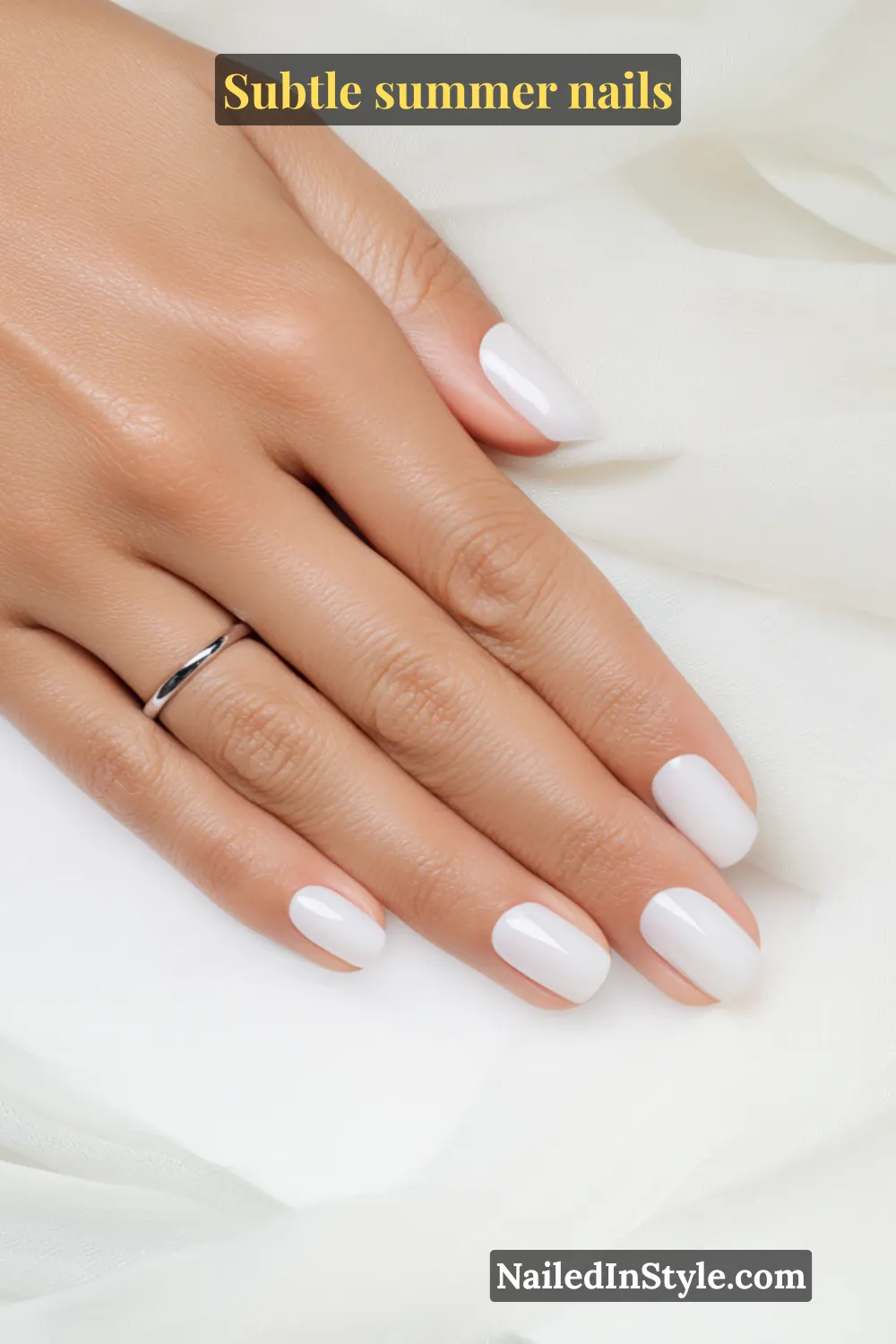 Short, rounded nails painted in a glossy milky white polish, giving a clean and timeless summer look.