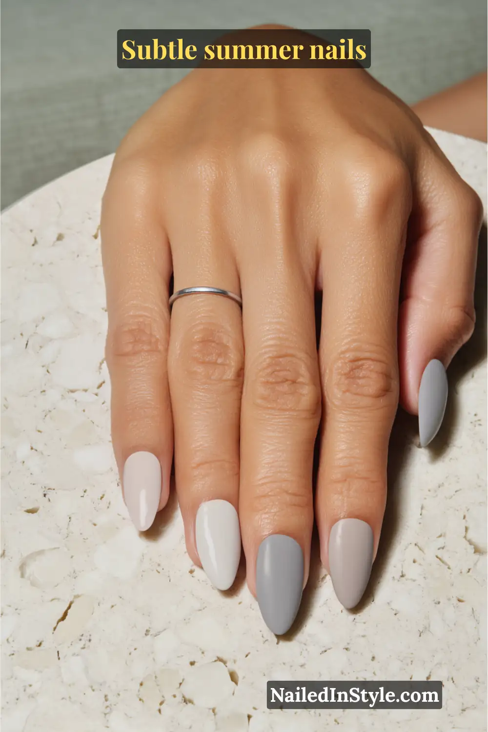 Glossy almond-shaped nails in taupe, dove gray, and ivory with a sleek matte tip accent.