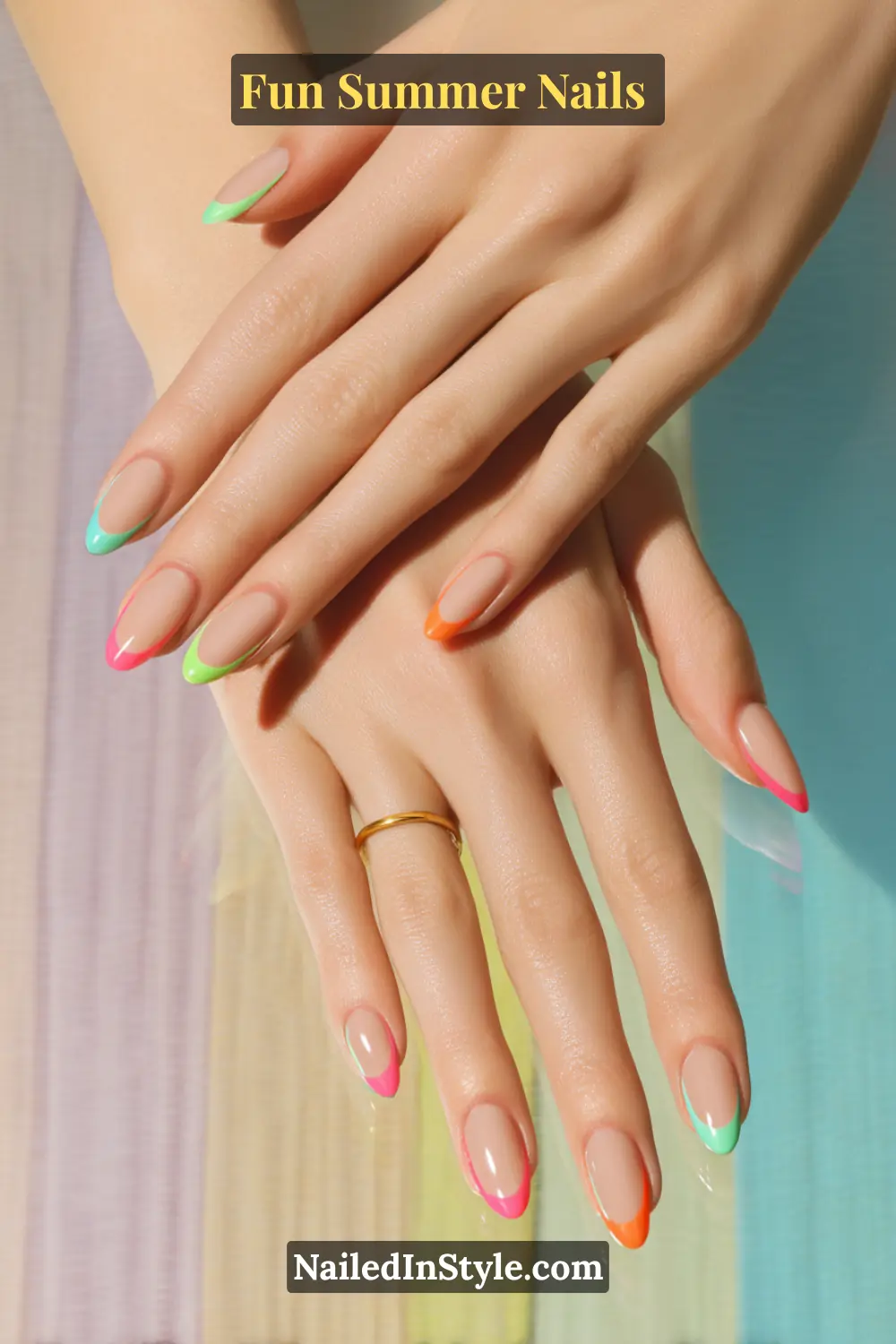 Hands with almond-shaped nails in a nude base and bright neon French tips in pink, green, orange, and blue.