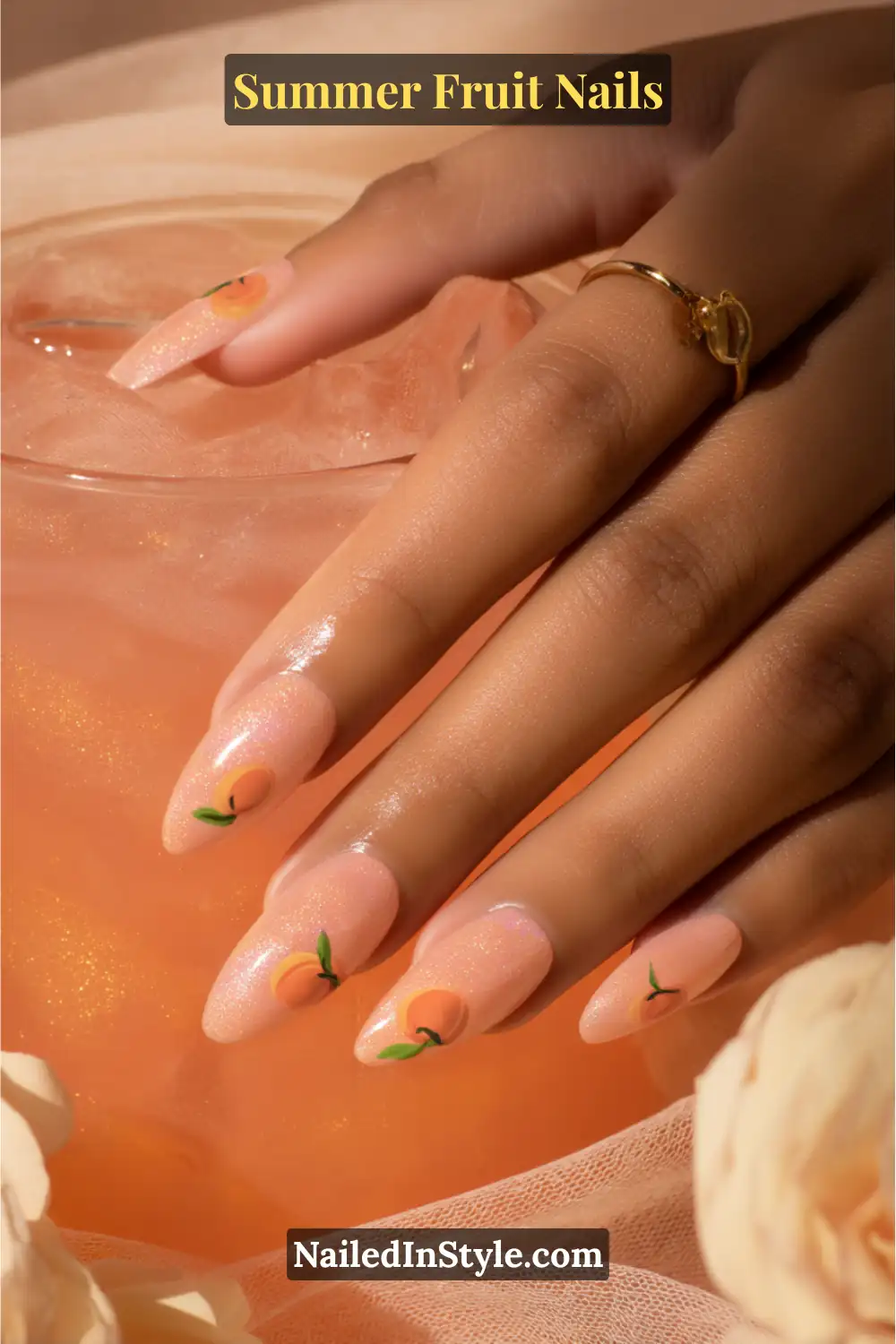 Long almond-shaped nails with a soft peach shimmer base, delicately adorned with small, realistic peach fruit art and tiny green leaves.