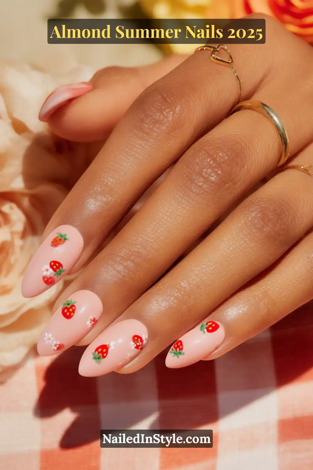Almond Summer Nails 2025: Sleek, Stylish & Seriously Stunning 16 Hand with almond-shaped nails in soft pink, decorated with tiny red strawberry and white flower decals