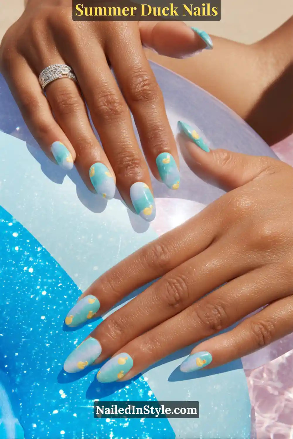 Cute Summer Duck Nails You’ll Want in 2026 2 Almond-shaped nails in aqua and sky blue gradient with tiny yellow floating duck designs, evoking playful pool vibes.