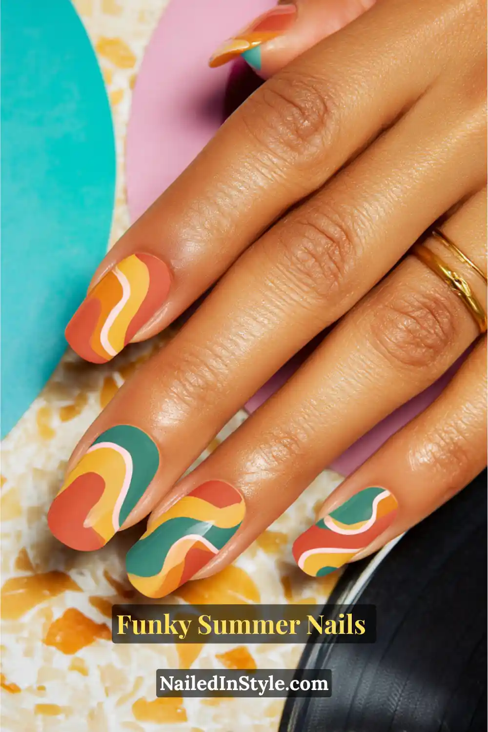 Close-up of square-shaped nails painted with bold retro swirls in orange, teal, mustard yellow, and coral pink, inspired by 70s pop-art patterns for a funky summer vibe.