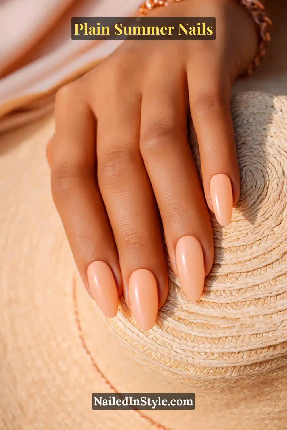 Plain Summer Nails 2025: Simple & Timeless Beauty 15 Hand with soft peach nude nails, radiating warm summer elegance against a woven sun hat.