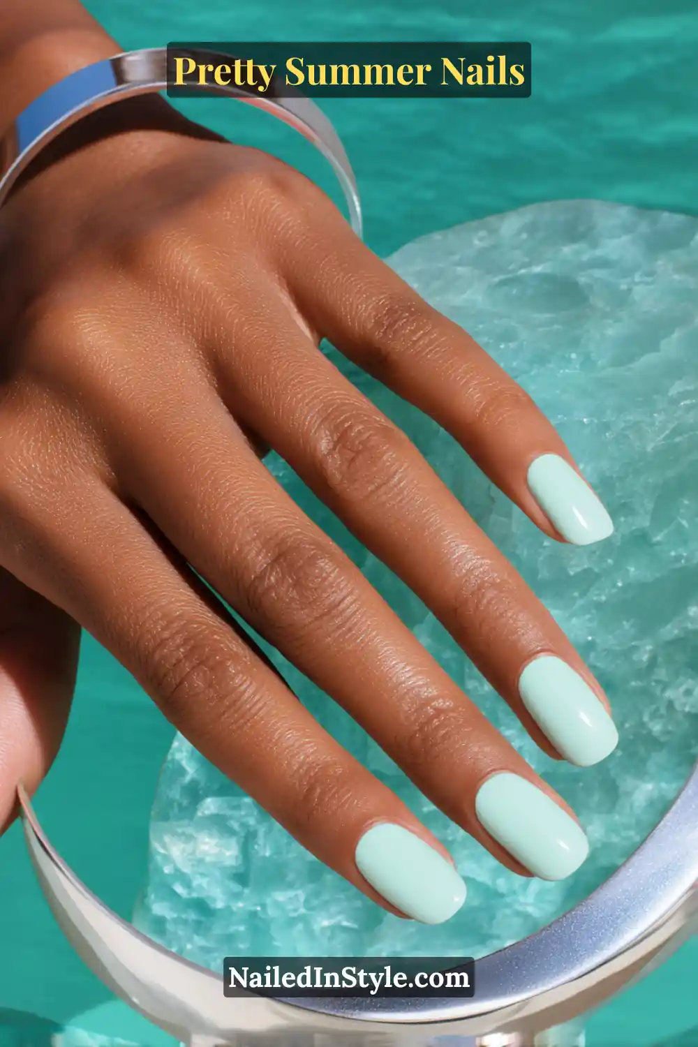 Close-up of hand with short square nails painted in glossy mint pastel polish.