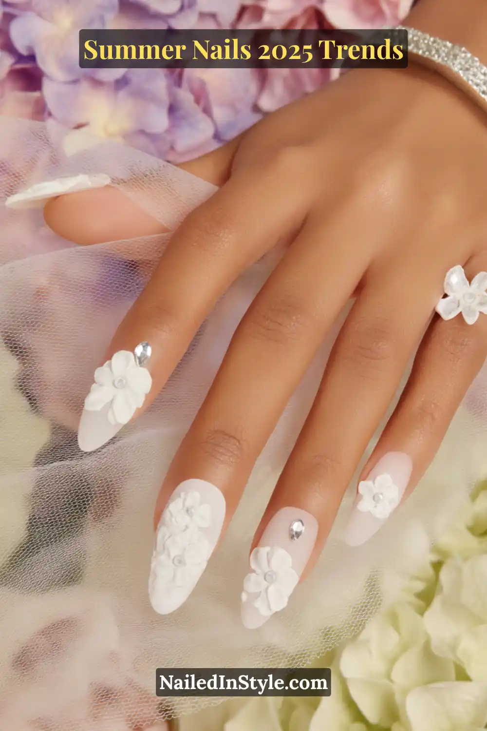 Matte almond nails with white 3D flowers and silver rhinestone details