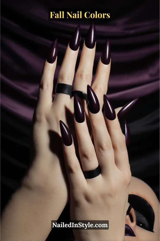 Glossy blackberry purple nails on dark skin, styled with bold matching lipstick for a gothic fall vibe.