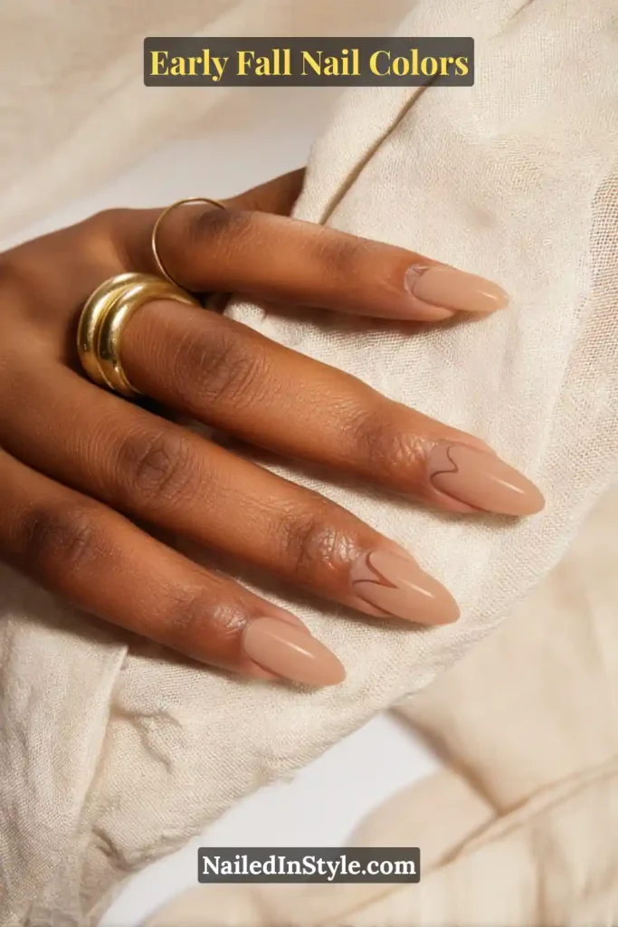 Early fall nail colors in caramel moon style with negative-space half-moon outlines, paired with a brass cuff and linen fabric.