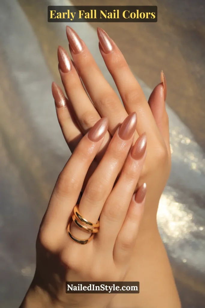 Early fall nail colors in sheer copper wash with glossy finish, styled with sunlight and stacked gold rings.