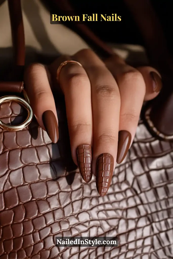 Deep cocoa nails with raised crocodile-skin texture on accent fingers.