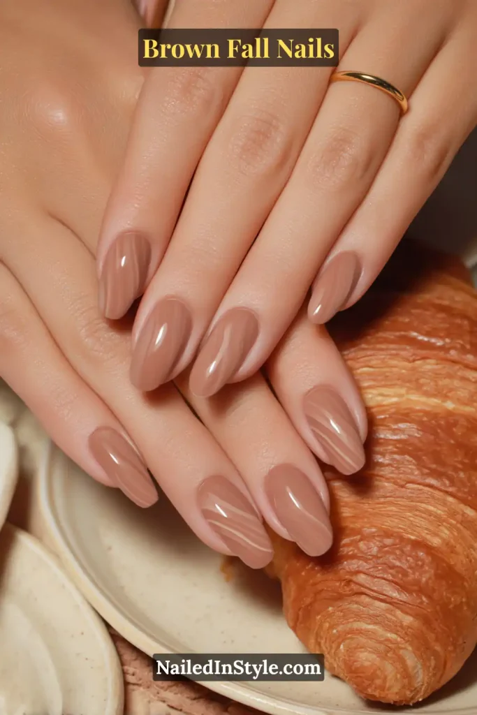 Brown fall nails with layered butter-tan and cocoa curved swirls, inspired by croissant pastry.