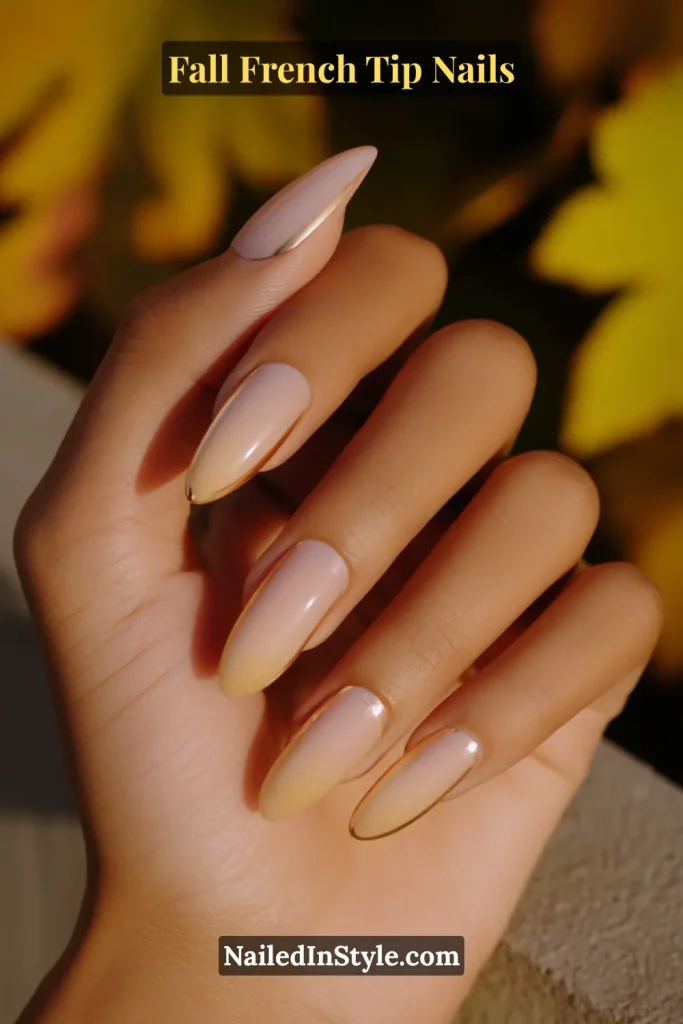 Almond nails in nude with thin metallic copper chrome French tips, hand in autumn sunlight.