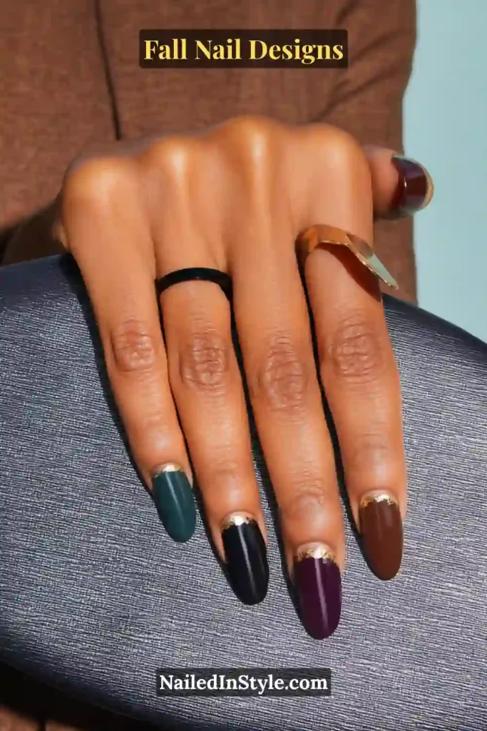 Fall Nail Designs Glossy almond nails in green, black, plum, and brown with gold foil crescents, hand on metallic clutch.