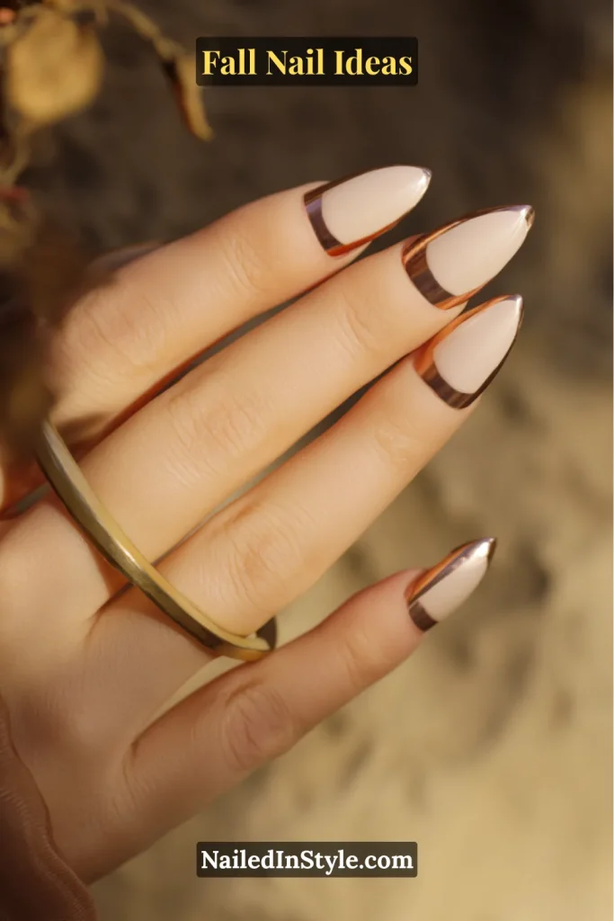 Fall Nail Ideas: 21 Gorgeous Looks to Try Now 5 Fall Nail Ideas Almond nails in nude with metallic copper chrome French tips, photographed in warm sunlight.