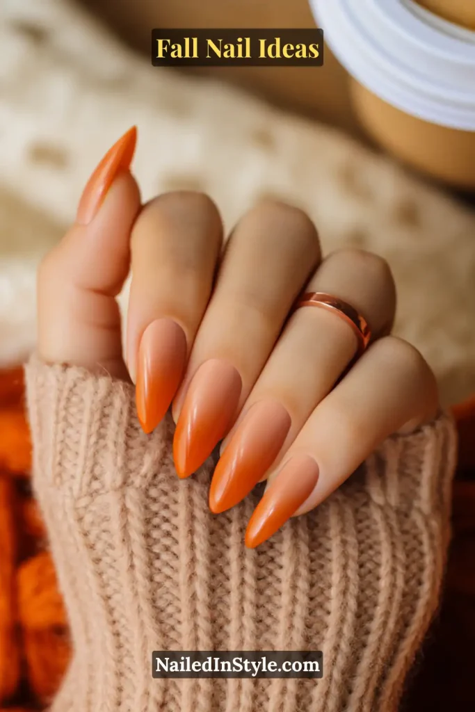 Fall Nail Ideas: 21 Gorgeous Looks to Try Now 3 Almond nails with nude-to-orange ombré gradient, hand in a beige knit sleeve holding a latte.