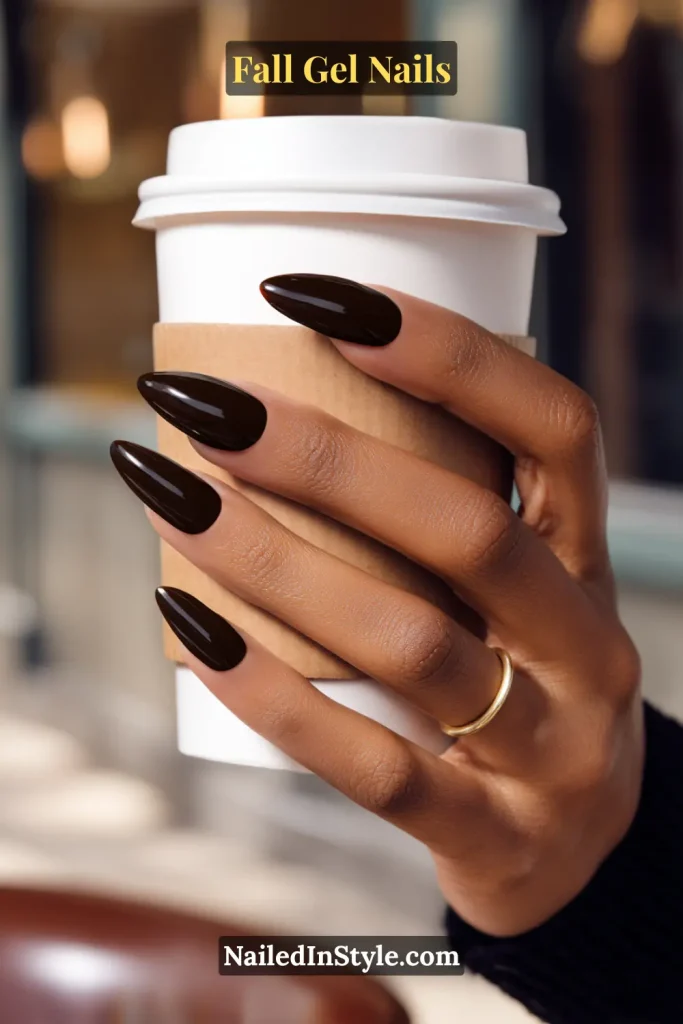 fall gel nails in glossy espresso brown polish holding a latte cup with sleeve during a cozy coffee run, sleek almond shape