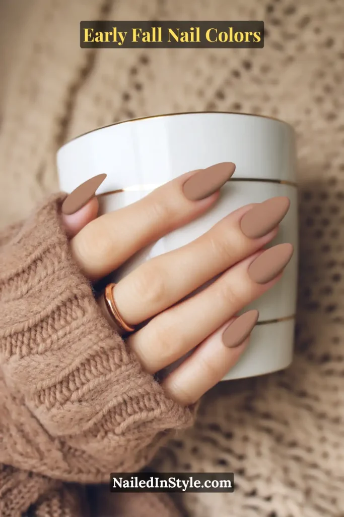 Early fall nail colors in matte latte suede with a soft velvet texture, styled with a cozy cable-knit sweater and ceramic mug.