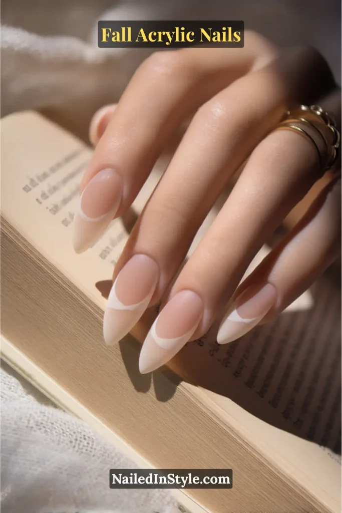 Almond-shaped nude acrylic nails with crisp negative-space side French tips in white.