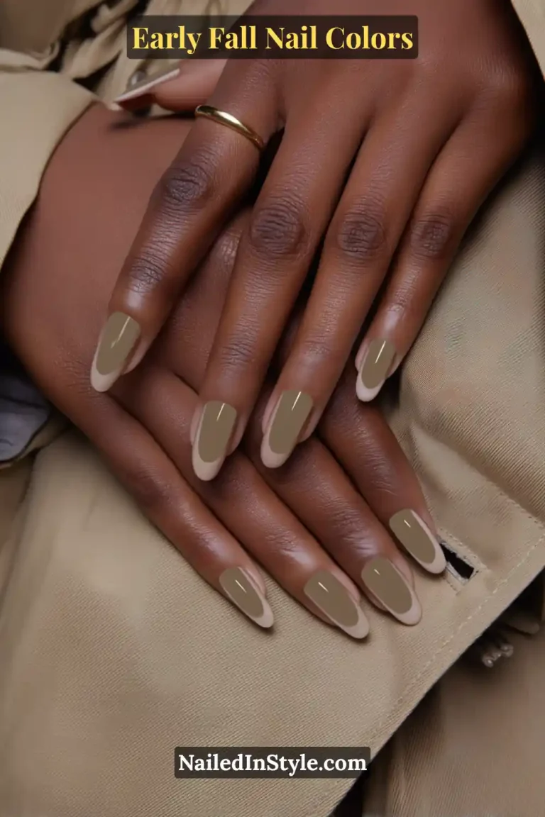 Early fall nail colors in olive contour French tips with an ultra-thin outline, styled against a trench coat lapel for a modern chic look.