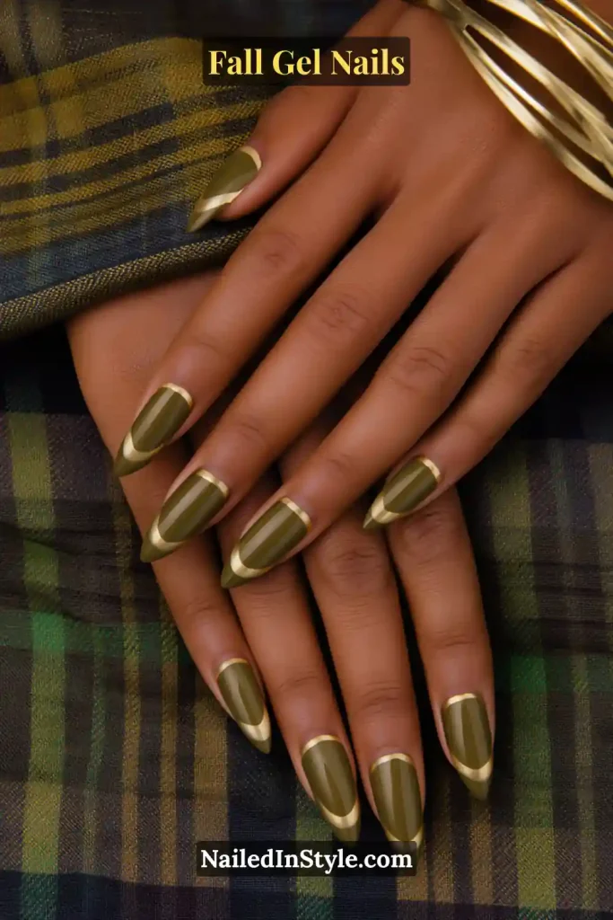 fall gel nails with olive green base and gold outline frame, almond shape, hands resting on plaid scarf fabric