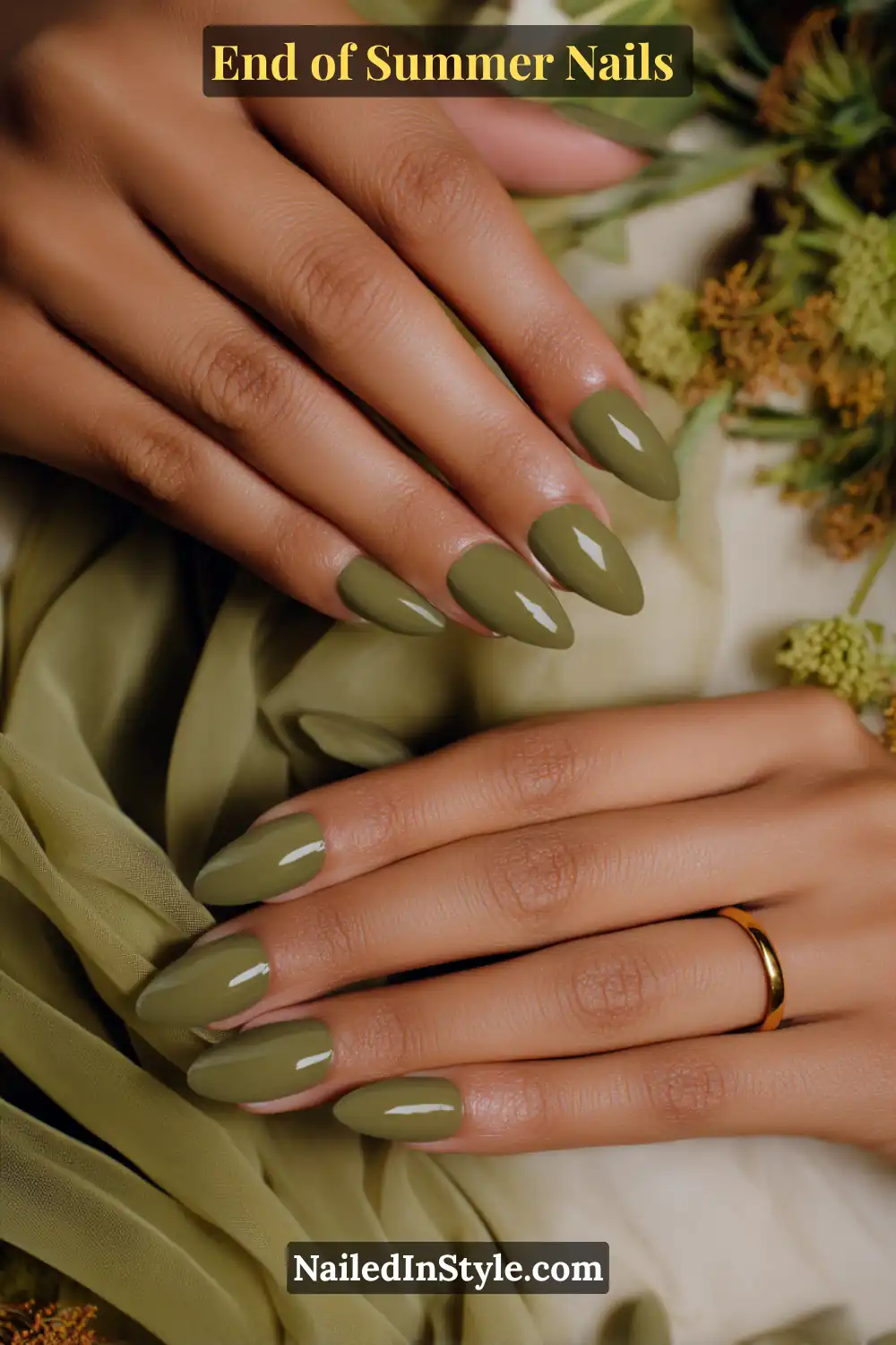 Two hands with almond-shaped nails painted in an earthy olive green shade, styled with a glossy finish.