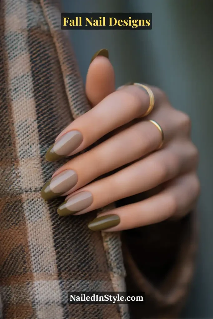 Hand with nude base nails and moss-green French tips, resting on a plaid/tweed coat sleeve—fall nail design.