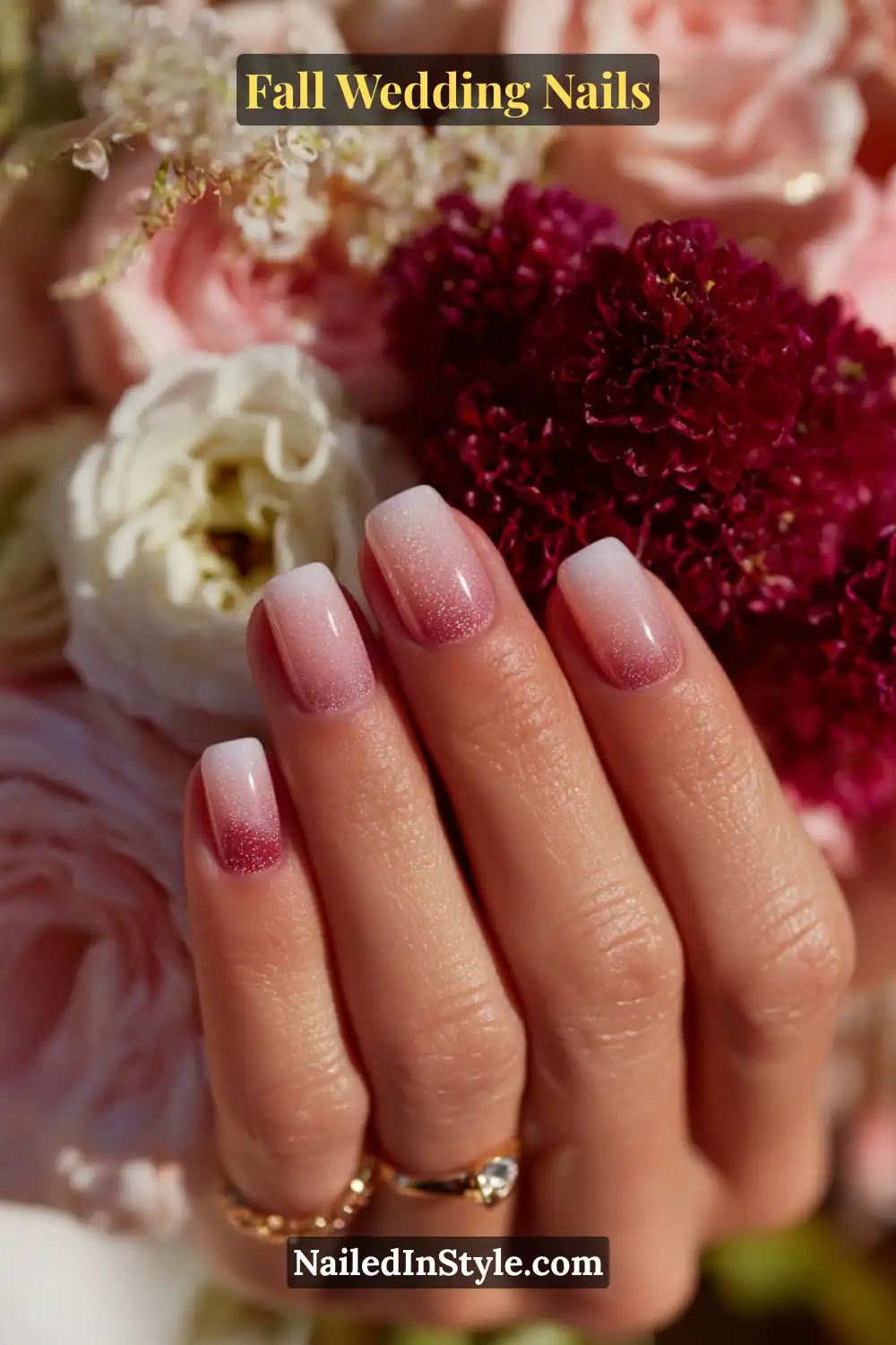 Close-up of fall wedding nails in blush pink fading into deep berry ombre with a soft velvet shimmer, bride holding berry-toned bouquet.