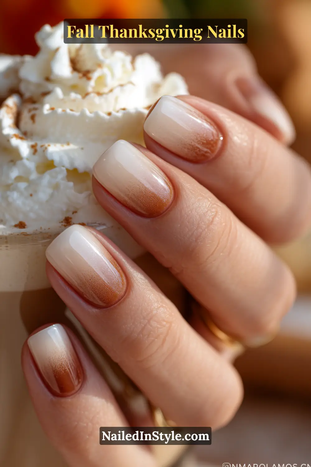 Close-up of maple glaze gradient Thanksgiving nails with ombre fade from latte beige to maple brown, styled with coffee and whipped cream.