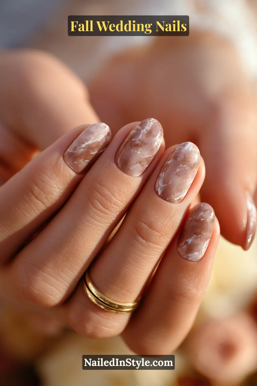 Close-up of fall wedding nails with mocha and beige marble swirl design, bride holding groom’s hand.