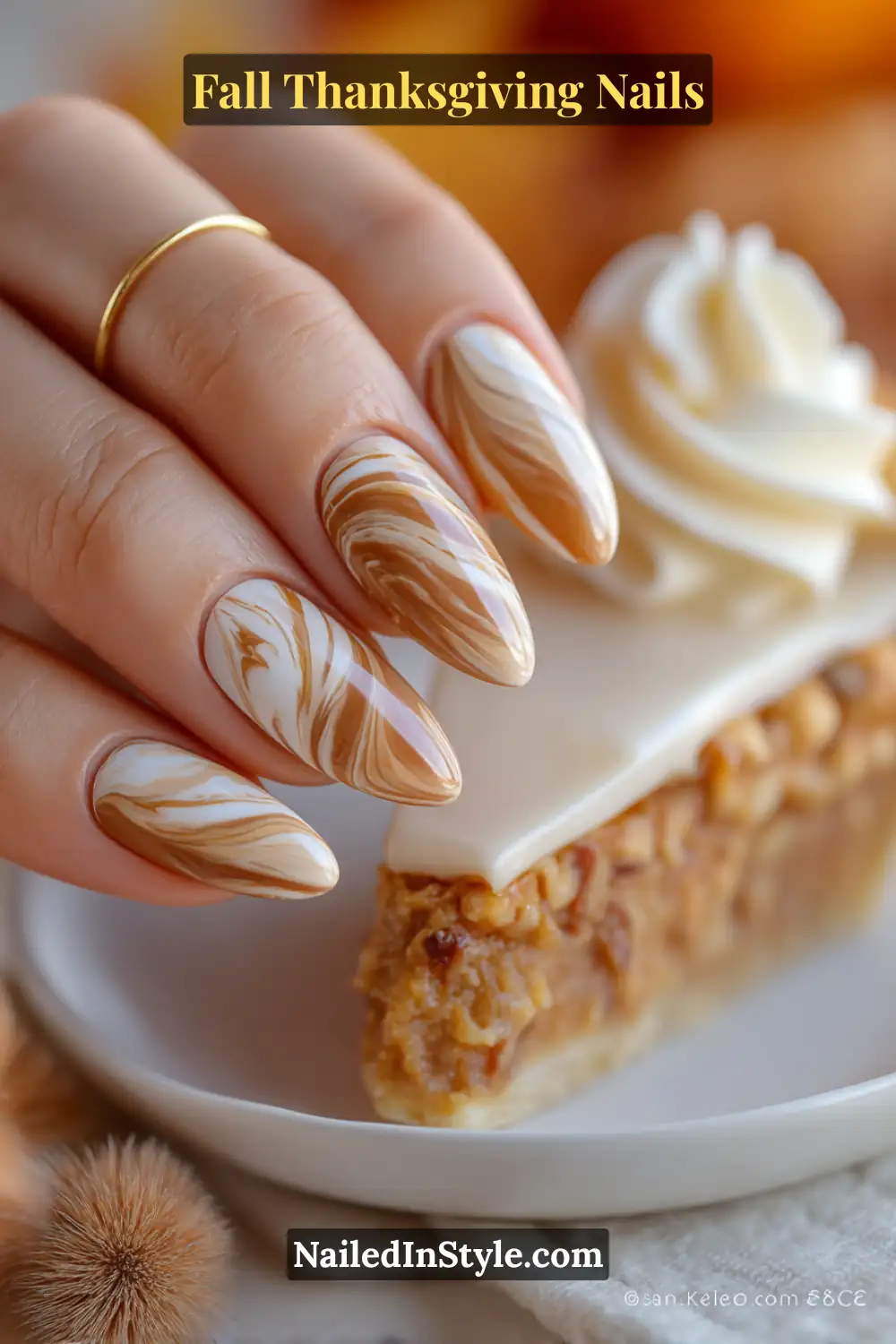 Close-up of pecan pie marble Thanksgiving nails with swirls of caramel, mocha, and ivory, styled above a slice of pecan pie.