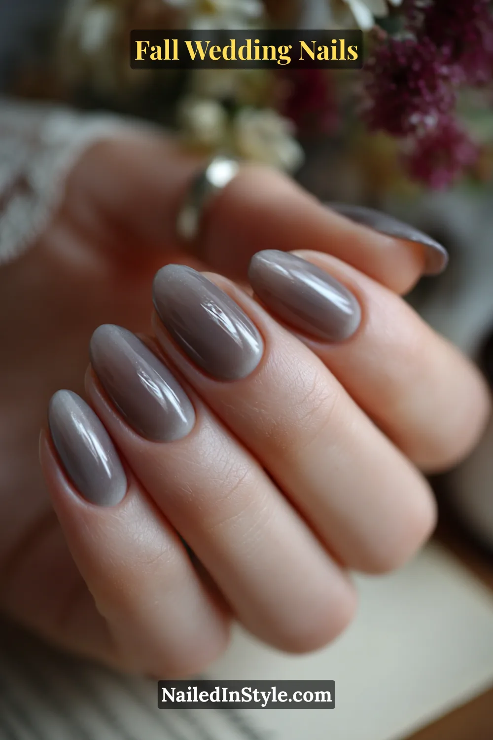 Close-up of taupe nails with a soft grey halo effect, bride signing her marriage license.