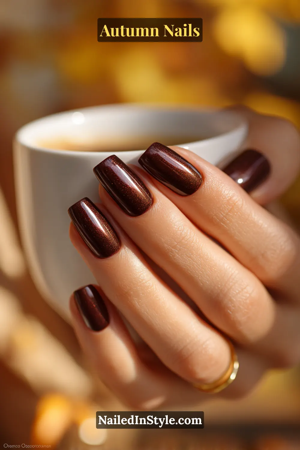 Close-up of velvet espresso autumn nails with cat-eye espresso polish and velvet shift effect, holding a coffee cup in fall light.