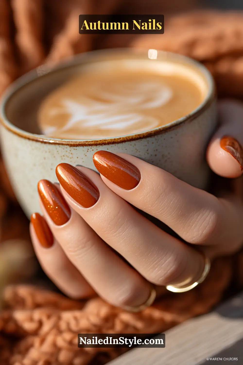 Close-up of velvet pumpkin chrome autumn nails in burnt orange with cat-eye magnetic velvet finish, holding pumpkin spice latte.