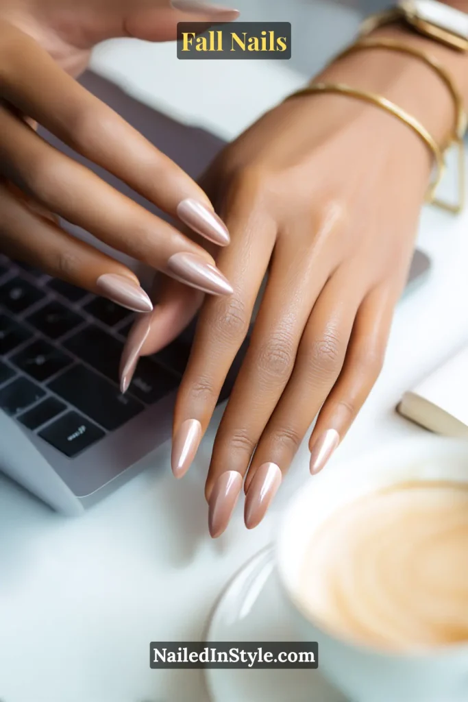 Almond fall nails in Toasted Almond Chrome with neutral chrome polish, styled near a laptop and latte for office-friendly shine.
